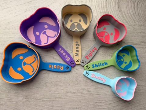 Dog food scoop with a raised puppy face on the cup and a paw print on the handle