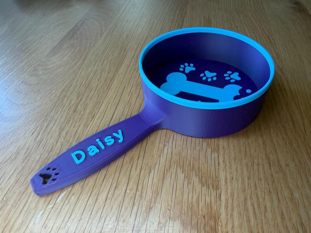 Blue and purple personalized dog food scoop printed with the name Daisy
