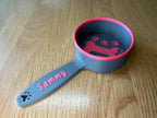 Grey and pink personalized dog food scoop printed with the name Sammy