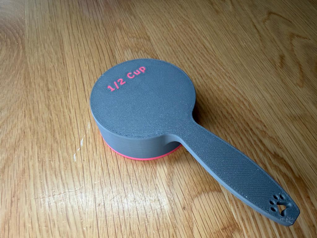 Grey dog food scoop showing the 1/2 cup size marking