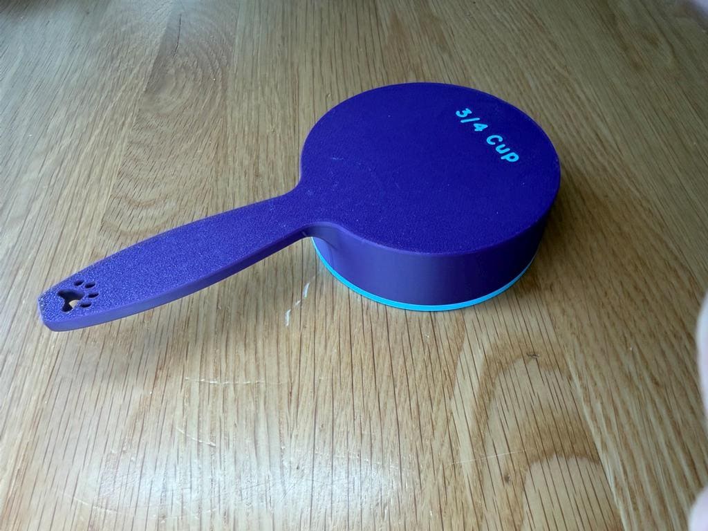 Blue dog food scoop showing the 3/4 cup size marking
