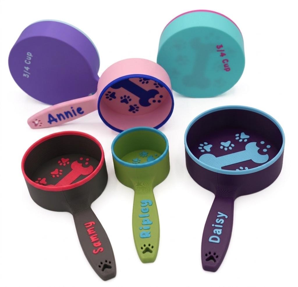 Group of personalized dog food scoops with names including Annie and Daisy, in assorted colors